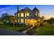 Beautiful home boasts manicured landscaping, warm lighting, and unique architectural details at dusk at 19006 69Th E Ave, Bradenton, FL 34211