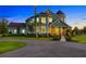 Charming two-story home features lush greenery, a circular driveway, and a welcoming porch at 19006 69Th E Ave, Bradenton, FL 34211