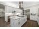 Modern kitchen features a large center island, white cabinets, quartz countertops, and stainless steel appliances at 19006 69Th E Ave, Bradenton, FL 34211