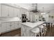 A modern kitchen features white cabinets, a large central island with seating, and an adjacent dining area at 19006 69Th E Ave, Bradenton, FL 34211
