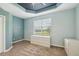 Serene bedroom featuring soft paint, tray ceiling, carpeting, and a view of the green scenery at 2353 Rosewood Ln, North Port, FL 34289