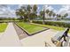 Well-maintained bocce ball court with artificial turf, surrounded by manicured landscaping and seating at 2353 Rosewood Ln, North Port, FL 34289