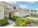 Charming townhouse featuring a vibrant red door, well-kept landscaping, and a two-car garage at 2353 Rosewood Ln, North Port, FL 34289
