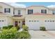 Inviting two-story townhouse with attached garage, manicured landscaping, and brick-lined driveway at 2353 Rosewood Ln, North Port, FL 34289