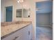 Bathroom with a granite countertop vanity, framed mirrors, and access to other rooms at 25 Sabot Ct, Placida, FL 33946