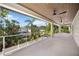 Expansive balcony with ceiling fans showcases the backyard's lush landscaping and modern fence at 2596 Floyd St, Sarasota, FL 34239