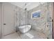 Bathroom with soaking tub and shower with marble surround at 2596 Floyd St, Sarasota, FL 34239