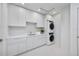 Modern laundry room with stacked appliances, and beautiful, bright, white cabinets at 2596 Floyd St, Sarasota, FL 34239