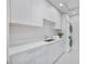 Well-equipped laundry room with stacked washer/dryer and storage cabinets at 2596 Floyd St, Sarasota, FL 34239