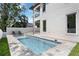 Back exterior of home with covered patios, a refreshing pool, and landscaped backyard at 2596 Floyd St, Sarasota, FL 34239