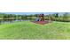 Large manicured lawn in back yard with playground, lake and partial fence at 2806 Starwood Ct, Lakewood Ranch, FL 34211