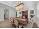 Elegant dining room with hardwood floors, modern lighting fixture and large wooden table set for six at 2806 Starwood Ct, Lakewood Ranch, FL 34211
