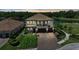 Elegant two-story home with a tile roof, paver driveway and three-car garage, located on a waterfront lot at 2806 Starwood Ct, Lakewood Ranch, FL 34211