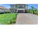 Charming two-story home featuring a brick driveway, an attached two-car garage, and a perfectly manicured lawn at 2806 Starwood Ct, Lakewood Ranch, FL 34211