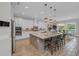 Open-concept kitchen features a large center island, stainless steel appliances, pendant lights, and dining area at 2806 Starwood Ct, Lakewood Ranch, FL 34211