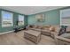 Bright living room with workout equipment, light wood floors, and multiple windows with white shutters at 2806 Starwood Ct, Lakewood Ranch, FL 34211