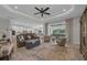 Open living room with modern furniture, wood floors, and a view of the lake and outdoor seating area at 2806 Starwood Ct, Lakewood Ranch, FL 34211