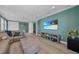 A spacious living room with a wall-mounted TV, light wood floors, and a comfortable sectional sofa at 2806 Starwood Ct, Lakewood Ranch, FL 34211