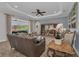 Bright and airy living room featuring stylish decor, tray ceiling, wood floors and sliding glass doors to outdoor entertainment space at 2806 Starwood Ct, Lakewood Ranch, FL 34211
