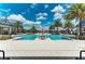 Stunning community pool surrounded by palm trees and lounge chairs on a sunny day at 2806 Starwood Ct, Lakewood Ranch, FL 34211