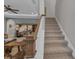 Carpeted staircase with white trim and wooden handrail leads to the upper level of the home at 2806 Starwood Ct, Lakewood Ranch, FL 34211