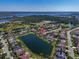 An aerial view of a residential community with a central lake surrounded by houses and trees at 2816 88Th E Ave, Parrish, FL 34219