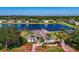 Stunning aerial view of lakeside home with mature landscaping, brick drive, and a defined property line outlined in red at 2816 88Th E Ave, Parrish, FL 34219