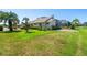 Large grassy backyard with mature trees, landscaping, and screened-in lanai at 2816 88Th E Ave, Parrish, FL 34219