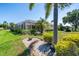 Expansive backyard featuring lush green grass, tropical landscaping, and a screened-in patio at 2816 88Th E Ave, Parrish, FL 34219