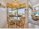 Sunlit dining area with a glass table, chairs, and views of the outdoor pool and patio at 2816 88Th E Ave, Parrish, FL 34219