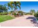 Spacious brick driveway leading to a well-manicured home, surrounded by lush greenery and tropical landscaping at 2816 88Th E Ave, Parrish, FL 34219