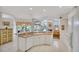 Open kitchen with a breakfast bar, white cabinetry, and views into the living area and pool at 2816 88Th E Ave, Parrish, FL 34219