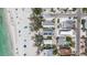 Birds eye view of a coastal community with private homes, palm trees, and a white sandy beach at 2918 Avenue E, Holmes Beach, FL 34217