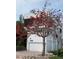 Modern white home featuring a two-car garage, exterior staircase, and a beautiful blossoming tree at 2918 Avenue E, Holmes Beach, FL 34217