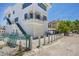 Bright white exterior of a multi-story home, featuring balconies, stairs and well-defined architecture at 2918 Avenue E, Holmes Beach, FL 34217