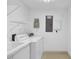 Functional laundry area with modern washer and dryer, storage shelves, and utility sink at 2918 Avenue E, Holmes Beach, FL 34217
