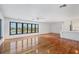 Spacious living room featuring hardwood floors, large windows, and kitchen access at 2918 Avenue E, Holmes Beach, FL 34217