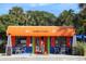 Charming restaurant exterior with outdoor seating and vibrant orange awning, inviting for a casual dining experience at 2918 Avenue E, Holmes Beach, FL 34217
