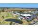 Overhead view featuring the community clubhouse, tennis courts, swimming pool, and surrounding golf course at 3007 Live Oak Ln, Palmetto, FL 34221