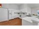 Bright kitchen features white cabinets, laminate countertops, stainless steel sink, and wood-look flooring at 3007 Live Oak Ln, Palmetto, FL 34221