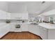 Bright kitchen features white cabinets, laminate countertops, stainless steel sink, and wood-look flooring at 3007 Live Oak Ln, Palmetto, FL 34221