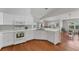 Bright kitchen features white cabinets, laminate countertops, stainless steel sink, and wood-look flooring at 3007 Live Oak Ln, Palmetto, FL 34221