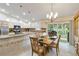 Open kitchen with granite countertops, an island with sink, stainless appliances, and adjacent dining area with sliding doors at 3453 Dryden St, North Port, FL 34288