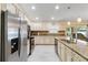 Well-lit kitchen features stainless steel appliances, tiled floors, granite countertops, and ample cabinet space at 3453 Dryden St, North Port, FL 34288
