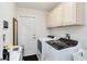 Functional laundry room with modern washer and dryer, white cabinets, and ample storage space at 3453 Dryden St, North Port, FL 34288