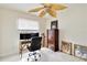 Well-lit home office featuring a desk, rolling chair, and decorative leaf ceiling fan at 3453 Dryden St, North Port, FL 34288