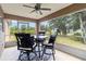 Inviting screened patio with a ceiling fan and outdoor dining set with a view of the surrounding greenery at 3453 Dryden St, North Port, FL 34288
