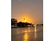 Sunset view of the waterway highlighting the glowing horizon and the silhouette of the distant landscape at 36 N Starboard Dr, Venice, FL 34285