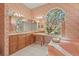 Bright bathroom featuring a tub, dual vanities, and a large window at 4180 Via Mirada, Sarasota, FL 34238