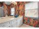 Stylish bathroom showcasing a vessel sink, white vanity, colorful wallpaper, and natural light at 4180 Via Mirada, Sarasota, FL 34238